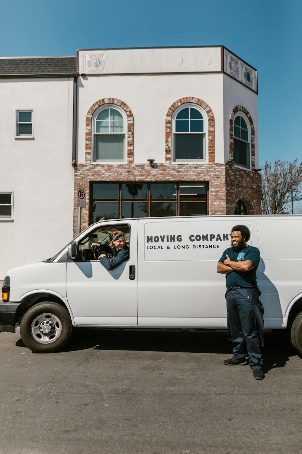 Metro Relocators moving crew standing by their branded local and long distance moving van