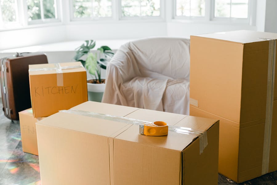 Cardboard boxes labeled for each room inside a furnished apartment during a residential move